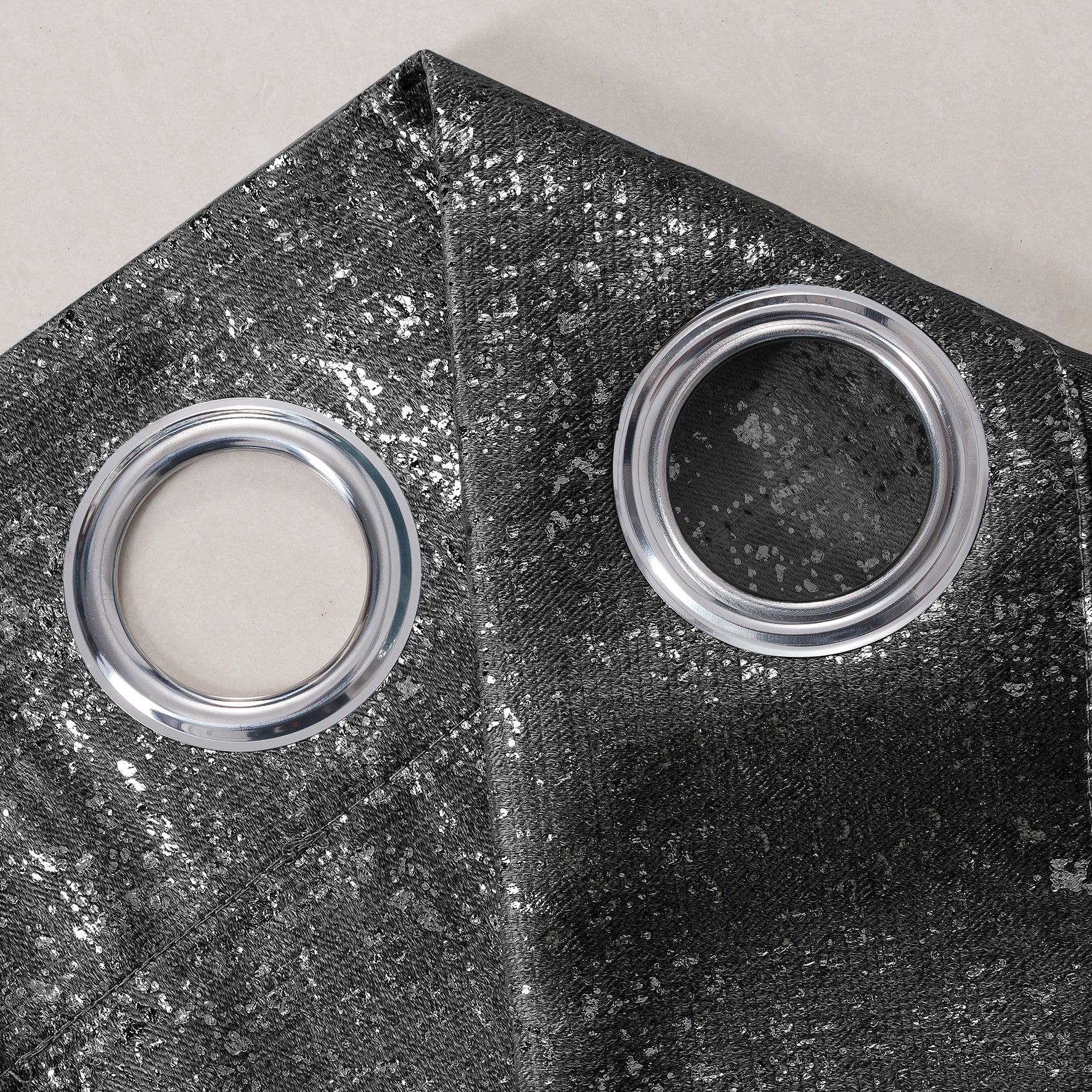 Close-up of a black curtain with two circular metal grommets.