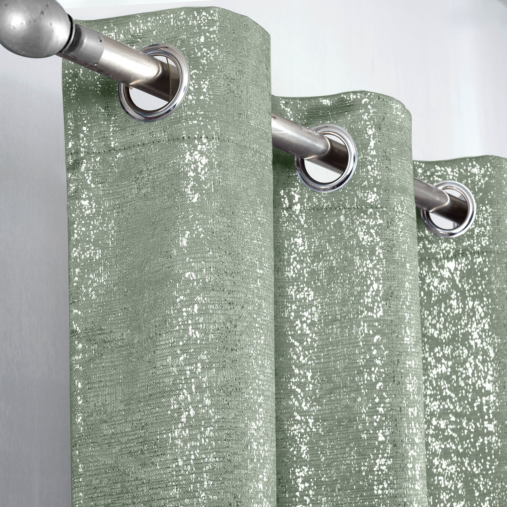 Sage Green Glittery curtain with silver grommets on a gray background