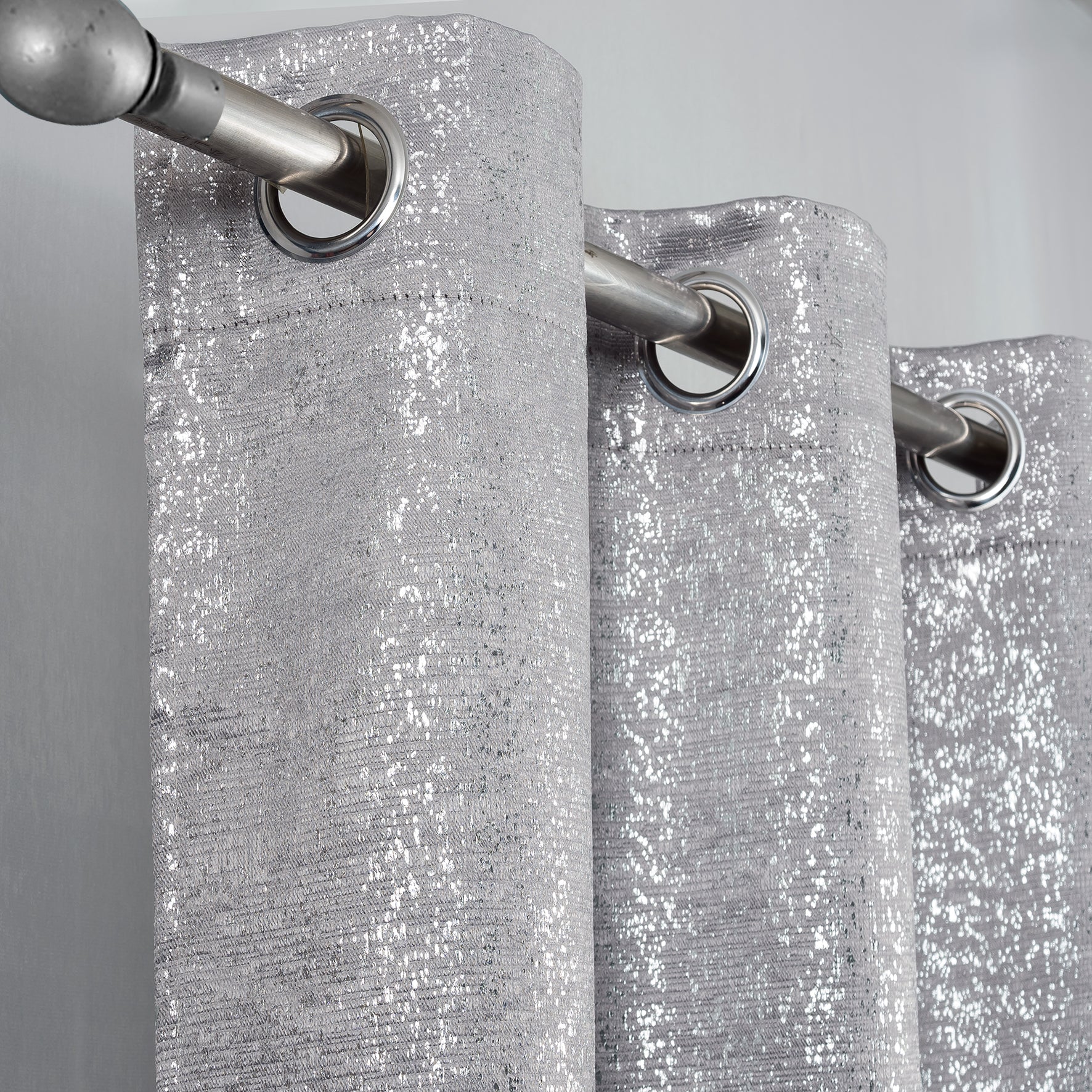 Silver Glittery curtain with silver grommets on a gray background